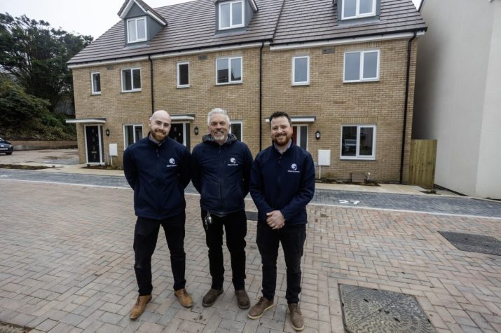 The site team for Respryn Roads development stand proudly in front of a terrace of new homes in the development.