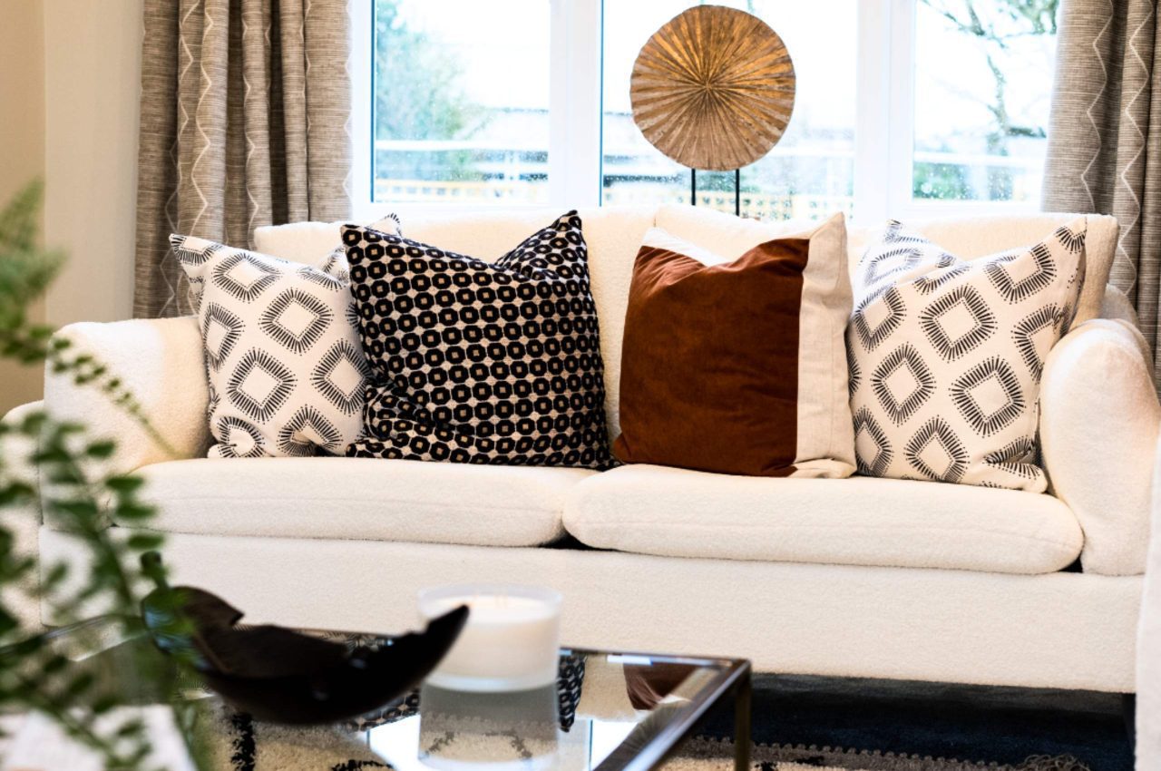 Image of a white sofa with window behind looking out onto the homes rear garden.