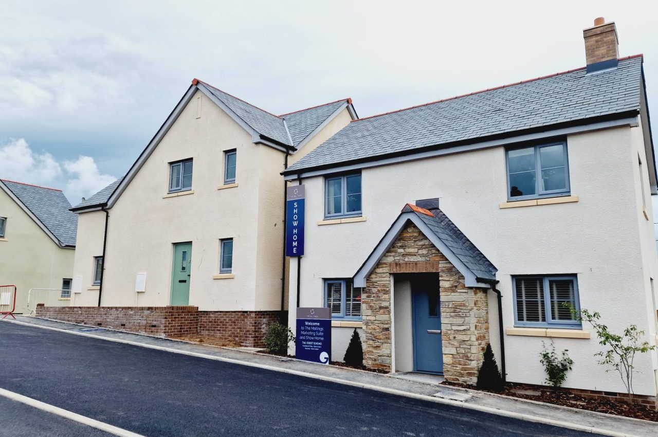 Picture of a rendered cream home with stone traditional porchway.