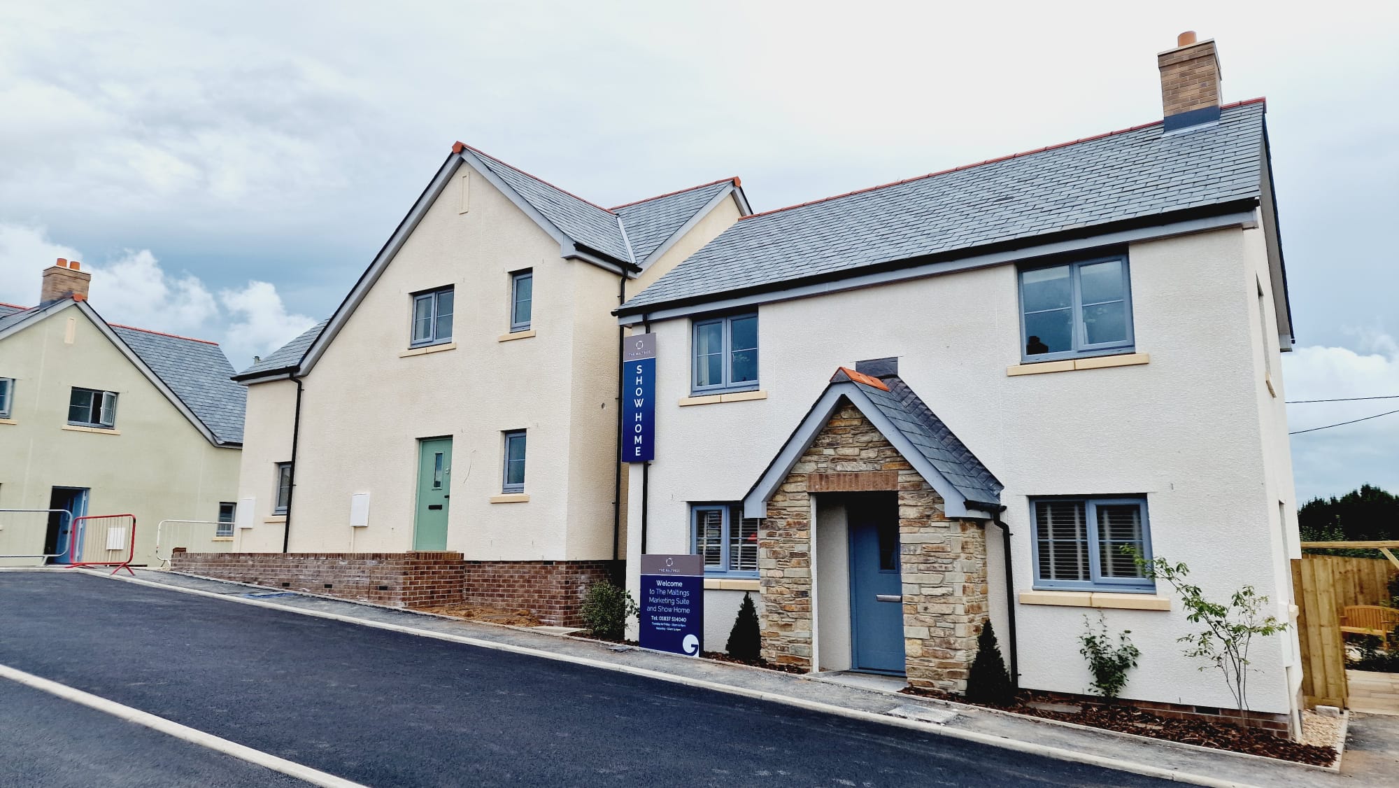 Picture of a rendered cream home with stone traditional porchway.